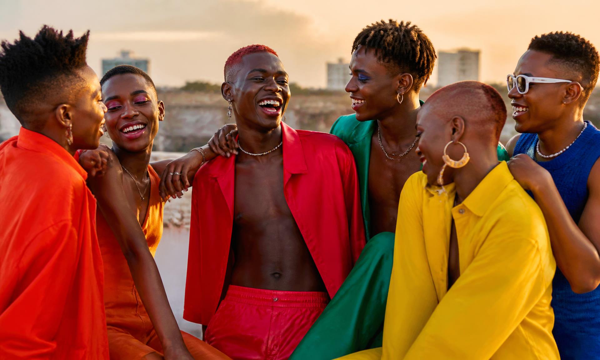 Joyful group of East African LGBTQ+ friends laughing together at golden hour